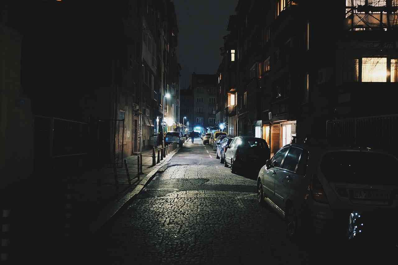Припаркованные машины на плохоосвещенной улице ночью